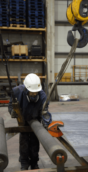 Trabajador usando maquinaria para mover una plancha de metal